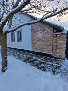 a brick building with snow on the ground at Borka-land Vendégház in Deszk