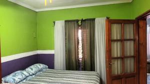 a bedroom with green and purple walls and a bed at Ester in San Antonio Oeste