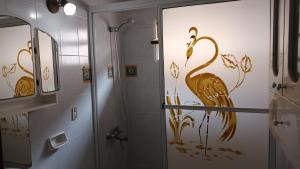 a bathroom with a shower with a painting of a bird at Ester in San Antonio Oeste