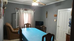 a dining room with a blue table and a television at Ester in San Antonio Oeste