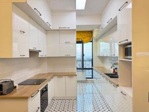 a kitchen with white cabinets and a tile floor at Harmony apartment in Bishkek
