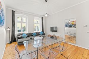 a living room with a glass table and a couch at primeflats - Apartments Genter Berlin-Wedding in Berlin
