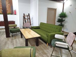 a living room with a green couch and chairs at Casa Dana, Losar de la Vera in Losar de la Vera