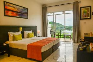 a hotel room with a bed and a large window at Agbo Hotel in Polonnaruwa +66 photos