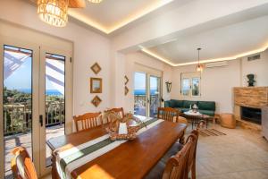 a dining room with a table and a fireplace at Great Escape Sea View Private Pools, Jacuzzi & Ultimate Relaxation in Maroulás