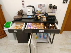 a counter with a table with donuts and a refrigerator at La Corte Nelle Vigne in Lavagno