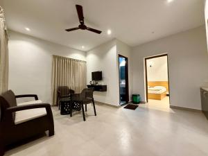 a living room with a ceiling fan and a table at Malpe Serene Stays in Malpe