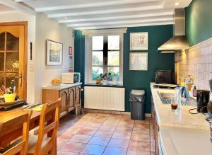 a kitchen with green walls and a table and chairs at Les Ruisseaux in Gedinne +31 photos