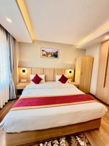 ein Schlafzimmer mit einem großen Bett und roten Kissen in der Unterkunft Hotel Aerocity in Kathmandu