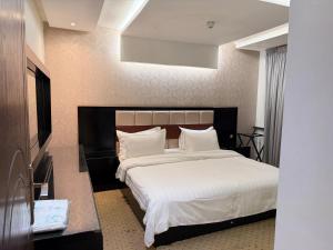 a bedroom with a large bed with white sheets and pillows at اكارم - إشبيلية - Akarem - iishbilia - اقتصادي in Riyadh +51 photos