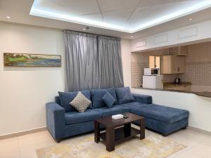 a living room with a blue couch and a table at اكارم - إشبيلية - Akarem - iishbilia - اقتصادي in Riyadh
