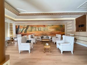a lobby with white chairs and a painting on the wall at اكارم - إشبيلية - Akarem - iishbilia - اقتصادي in Riyadh