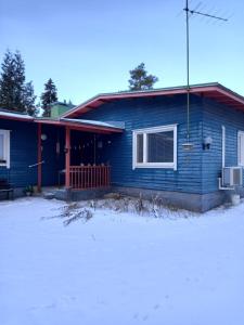 a blue house in the snow in front at Blue House Nature Retreat with Private Garden in Sastamala