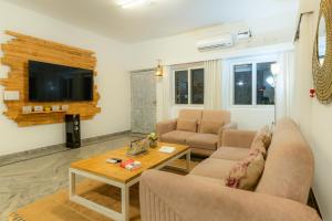 a living room with two couches and a table at Alaya Stays Luxe FarmAcre Pet-friendly 4-BHK Villa With Private Pool, Garden & Terrace in Gurgaon
