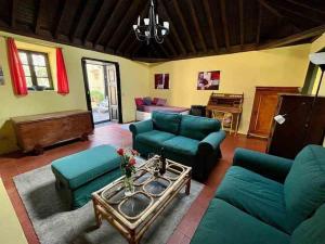 ein Wohnzimmer mit blauen Sofas und einem Tisch in der Unterkunft Finca Panadera, Ferienhaus in Tijarafe in Tijarafe