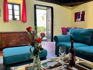 ein Wohnzimmer mit blauen Sofas und einer Flasche Wein in der Unterkunft Finca Panadera, Ferienhaus in Tijarafe in Tijarafe