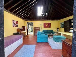 ein Wohnzimmer mit einem blauen Sofa und einem Tisch in der Unterkunft Finca Panadera, Ferienhaus in Tijarafe in Tijarafe + 13 Fotos