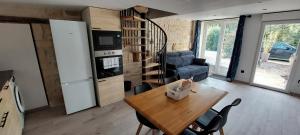 a kitchen and living room with a table and a couch at Gite Rive Charente La Cabane in Bords