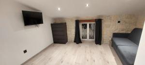 a living room with a couch and a flat screen tv at Gite Rive Charente La Cabane in Bords