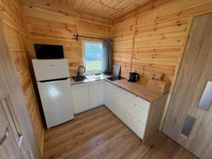 a kitchen in a log cabin with a refrigerator at Domki letniskowe Ruś in Ruś