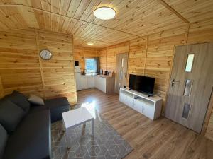 a large living room with a couch and a tv at Domki letniskowe Ruś in Ruś