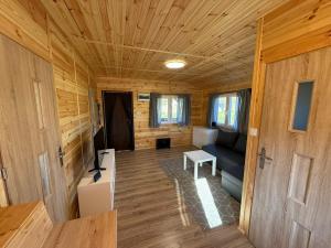 a living room in a tiny house with a couch at Domki letniskowe Ruś in Ruś