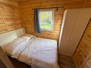 a bedroom in a log cabin with a bed and a window at Domki letniskowe Ruś in Ruś +18 photos