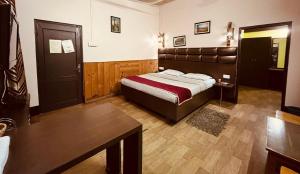 a bedroom with a bed and a table in it at Executive Guest House in Guwahati