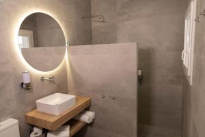 a bathroom with a sink and a mirror at UVA Apartamentos in Badajoz +8 photos