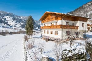 ein Haus im Schnee mit einem schneebedeckten Hof in der Unterkunft Silberkrug in Dorfgastein