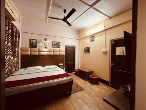 a bedroom with a bed and a ceiling fan at Executive Guest House in Guwahati