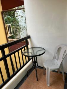 a table and a chair sitting on a balcony at Pathaya in Ban Kata
