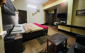 a room with a bed and a table and a chair at Executive Guest House in Guwahati