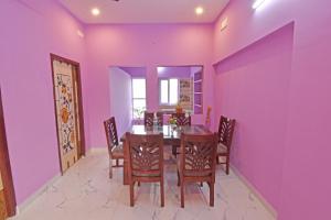 a dining room with purple walls and a table and chairs at SRK Residency in Pūrnānkuppam
