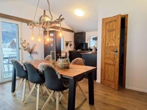 a kitchen and dining room with a wooden table and chairs at Bijou Hollandia in Engelberg