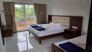 a bedroom with two beds and a large window at Machan Villas by Holiday Club in Bhor
