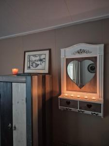 a mirror on a dresser in a room at Parel van het bos in Norg