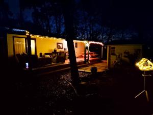 a house lit up at night with a living room at Parel van het bos in Norg +10 photos