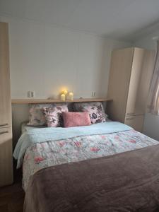 a bedroom with a large bed with pink pillows at Parel van het bos in Norg