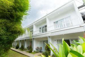 an exterior view of a white building with plants at DJourney Hotel Lembang by Escotel in Bandung