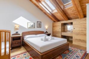 a bedroom with a bed in a room with wooden ceilings at Hostdomus - Chalet Wood in Sauze d'Oulx