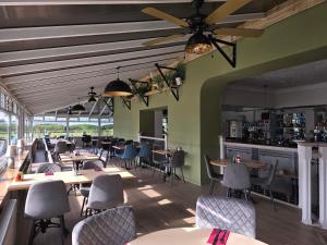 a restaurant with tables and chairs and a bar at Ashburnham Hotel in Pembrey