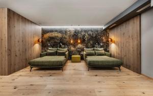 a room with two chairs and a wall with a painting at Hotel Fliana 4-Sterne Superior in Ischgl
