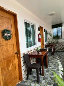 a room with a wooden door and a table and chairs at Dreamstay Hostel in Moalboal