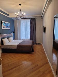 una camera da letto con un letto e un lampadario di David Hotel - Ethno style a Tbilisi City