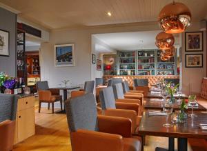 a restaurant with tables and chairs and a bar at Castlecourt Hotel, Spa & Leisure in Westport