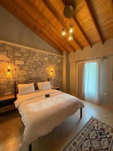 a bedroom with a large bed and a stone wall at LUTA Urla in Urla