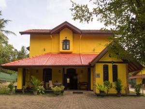 une maison jaune avec un toit rouge dans l'établissement Resort Like No Other, à Uggalboda