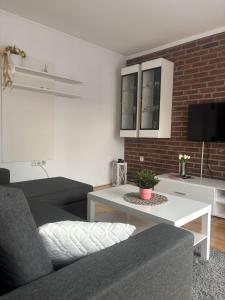 a living room with a couch and a table at Apartman Loni , Belišće in Belišće