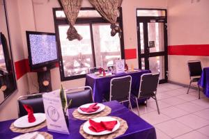 a restaurant with purple tables with red hats on them at HOTEL DE LA VALLEE NEW in Yaoundé